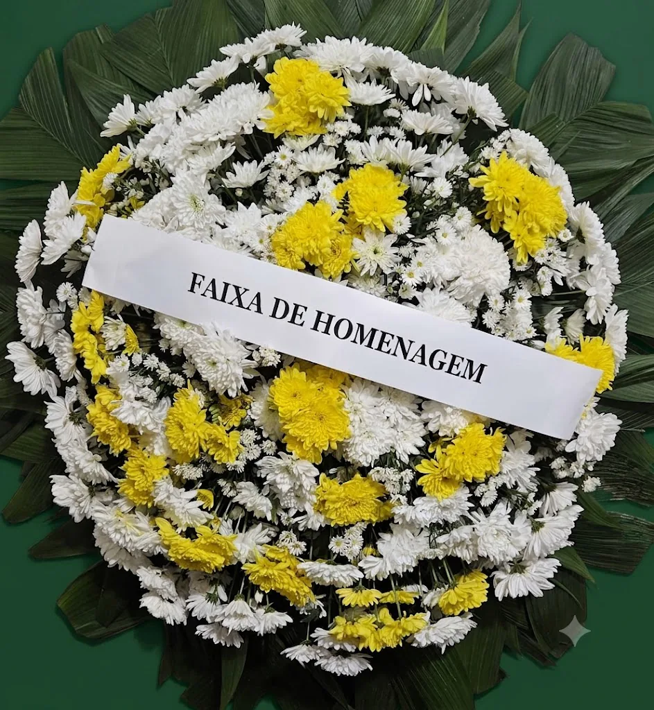 Coroa de crisântemos brancos e amarelos com faixa de homenagem